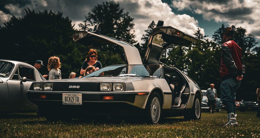 DeLorean with gullwing doors drawing a crowd