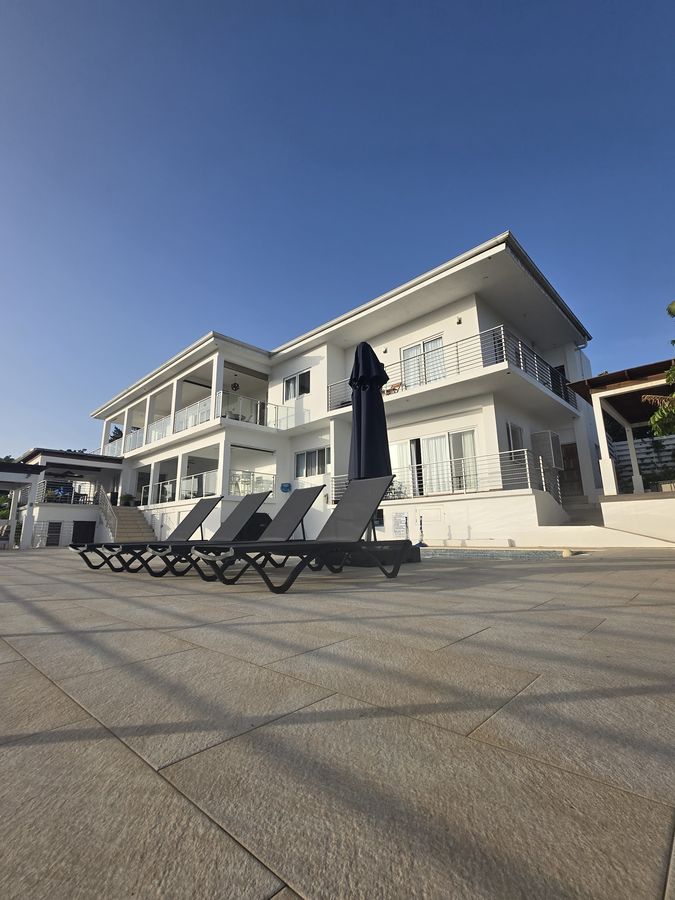 Modern villa exterior with poolside loungers