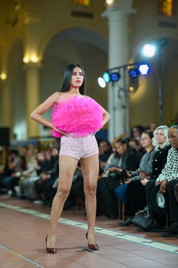 Model holding a pink tulle piece mid-runway
