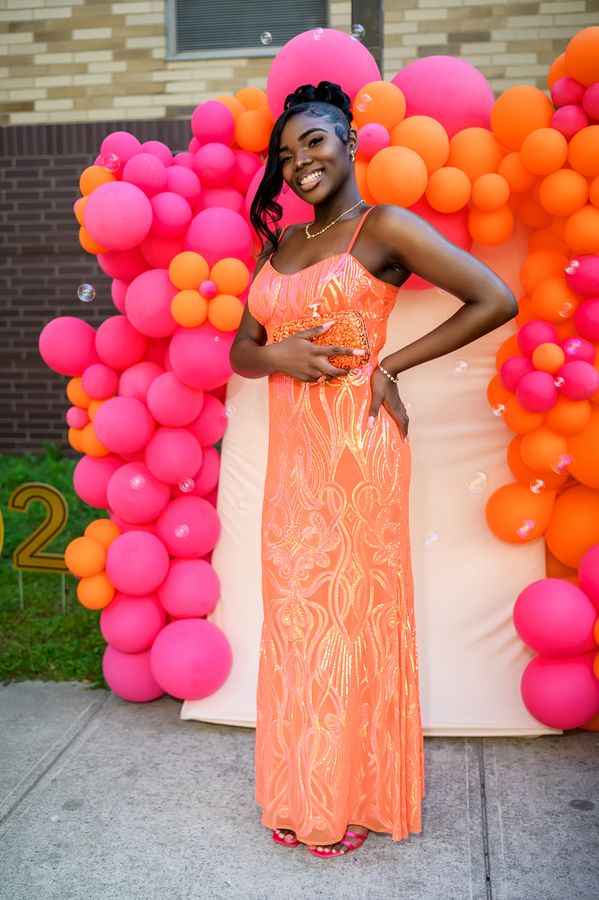 Portrait against a pink and orange balloon wall