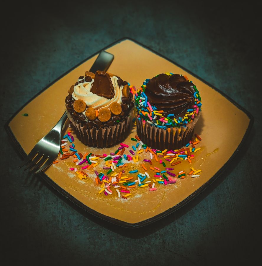 Gourmet cupcakes with sprinkles styled on a gold plate