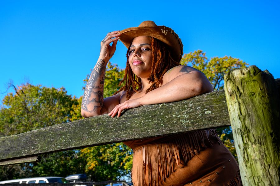 Golden-hour portrait at a wooden fence in a cowboy hat